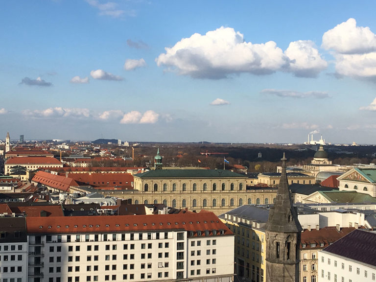 Der langgestreckte Königsbau gehört zur Münchner Residenz, dem Stadtschloss der bayerischen Könige. Rechts davon das Nationaltheater, im Hintergrund der Englische Garten mit dem Monopterus.